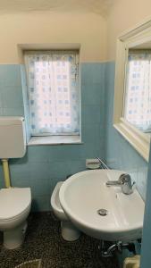 uma casa de banho com um WC branco e um lavatório. em Casa Vacanze Libarna Outlet em Serravalle Scrivia