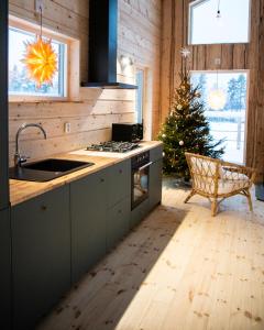 een keuken met een fornuis en een kerstboom bij BLUEBERRY LODGE 5 personnes in Mjölan