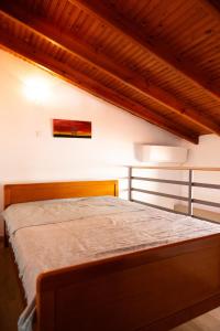 a bedroom with a bed with a wooden head board at Casa di Porto in Neos Marmaras