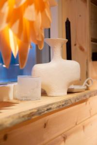 a white vase and a cup on a counter at BLUEBERRY LODGE 5 personnes in Mjölan