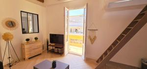 尼斯Le Virenque的一间带楼梯和电视的客厅