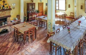 uma sala de jantar com mesas e cadeiras e uma lareira em Monterufoli 4f em Pomarance