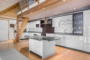 a kitchen with white cabinets and a wooden ceiling at Atlantic Road Seaside Housing in Averoy