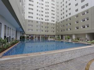 a large swimming pool in the middle of a building at Aurora Rooms @ Apartemen Loftvilles City in Dukuh