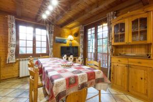 a dining room with a table and some windows at Chalet de 7 chambres avec terrasse et wifi a Saint Gervais les Bains in Saint-Gervais-les-Bains