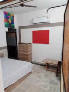 a room with a bed and a table and a bench at OP Krishna Homestay in Mathura