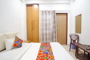 - une chambre avec un lit, une table et une chaise dans l'établissement FabHotel SK Residency, à Varanasi