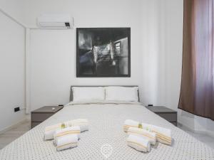 a bedroom with a bed with three pillows on it at Port View Apartment in Cagliari +19 photos