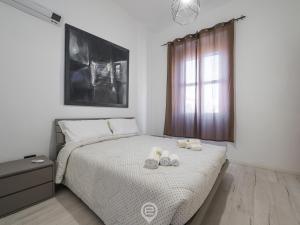 Un dormitorio con una cama con dos zapatos. en Port View Apartment, en Cagliari