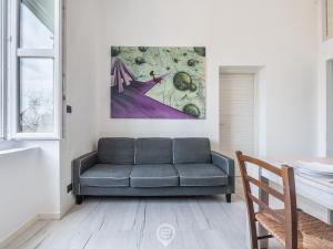 a living room with a couch and a painting at Port View Apartment in Cagliari