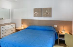 Schlafzimmer mit einem blauen Bett und einem Schreibtisch in der Unterkunft 2 Bedroom Cozy Home In Marina Di Ragusa in Marina di Ragusa