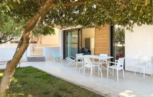 eine Terrasse mit einem Tisch und Stühlen unter einem Baum in der Unterkunft 2 Bedroom Cozy Home In Marina Di Ragusa in Marina di Ragusa + 29 Fotos