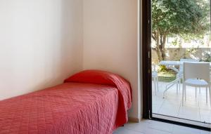 ein Bett mit einer roten Decke in einem Zimmer mit Terrasse in der Unterkunft 2 Bedroom Cozy Home In Marina Di Ragusa in Marina di Ragusa