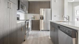 uma cozinha com um lavatório e um frigorífico em Landing Modern Apartment with Amazing Amenities (ID1210X718) em Wake Forest