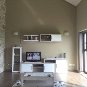 a living room with a tv on a wall at 4 bedrooms house with private pool jacuzzi and wifi at Roxos in Santiago de Compostela