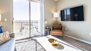 uma sala de estar com um sofá e uma televisão em Landing Modern Apartment with Amazing Amenities (ID1954) em Aurora