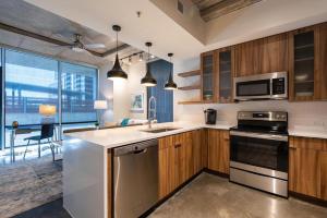 Landing Modern Apartment with Amazing Amenities (ID6221) في أوستن: مطبخ مع أجهزة ستانلس ستيل ودواليب خشبية