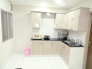 a kitchen with white cabinets and a sink at Al fazal Tower in Rāmkot