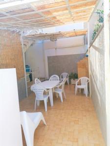 スコリッティにあるGambusiaのパティオ(白い椅子、テーブル、椅子付)