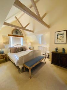 a bedroom with a large bed with a bench in it at Campden Mews in Chipping Campden