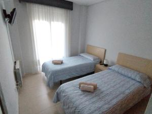 ein Hotelzimmer mit zwei Betten und einem Fenster in der Unterkunft Apartamento en la Torre Golf Resort in Torre-Pacheco