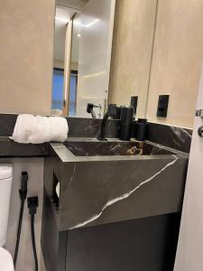 a bathroom with a sink and a mirror at Lindo estúdio em Marilia - ao lado do Ibis in Marília