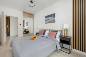 a bedroom with a bed with a bowl of fruit on it at Apartamenty Porta Mare by Renters in Dziwnówek