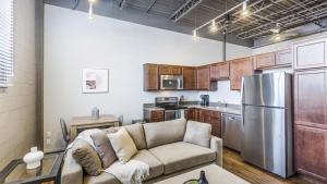 ein Wohnzimmer mit einem Sofa und einer Küche in der Unterkunft Landing Modern Apartment with Amazing Amenities (ID9106X83) in Omaha