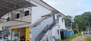 un edificio blanco con una escalera lateral en Sobey Laris Homestay Tanah Merah, en Tanah Merah