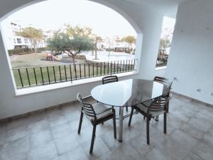 comedor con mesa, sillas y ventana en Apartamento en la Torre Golf Resort, en Torre-Pacheco