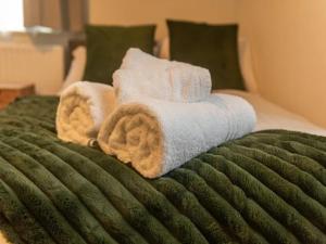 a green bed with towels on top of it at Pass the Keys Cosy Studio With Private Parking in Wolverhampton