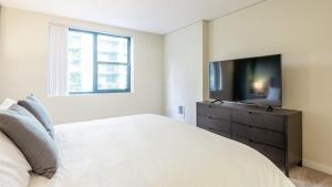 a bedroom with a bed and a flat screen tv at Landing Modern Apartment with Amazing Amenities (ID1593X6) in Portland