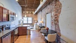 una cucina con muro di mattoni, tavolo e sedie di Landing Modern Apartment with Amazing Amenities (ID8369X10) a Omaha