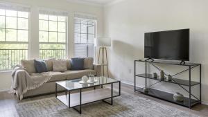 ein Wohnzimmer mit einem Sofa und einem Flachbild-TV in der Unterkunft Landing Modern Apartment with Amazing Amenities (ID1371X699) in West Chester