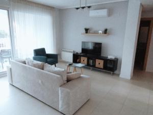 sala de estar con sofá y TV en Apartamento en la Torre Golf Resort, en Torre-Pacheco