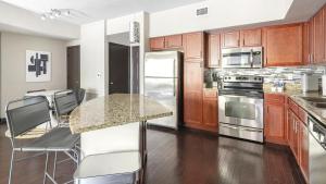una cocina con armarios de madera y una mesa con sillas. en Landing Modern Apartment with Amazing Amenities (ID4370), en Fort Lauderdale