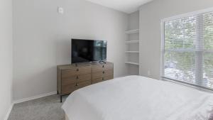 una camera con letto e TV a schermo piatto di Landing Modern Apartment with Amazing Amenities (ID3078X18) a Dallas