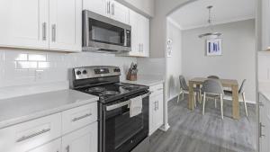 una cucina con piano cottura, forno a microonde e tavolo di Landing Modern Apartment with Amazing Amenities (ID3078X18) a Dallas