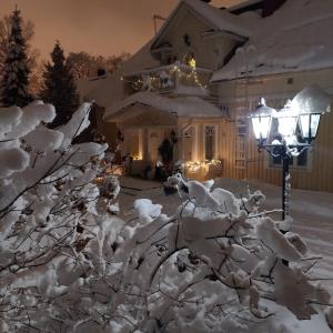 una casa cubierta de nieve junto a una luz de la calle en Luukkaan Helmi, en Lappeenranta