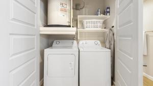 2 lavadoras en un lavadero con puertas blancas en Landing Modern Apartment with Amazing Amenities (ID8965X69) en San Antonio