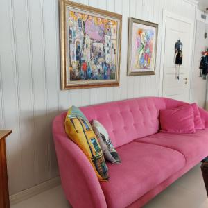 un sofá rosa con dos almohadas en una habitación en Luukkaan Helmi, en Lappeenranta