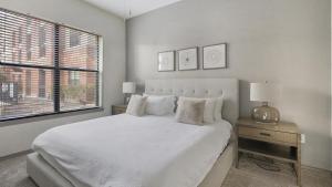 een witte slaapkamer met een groot bed en een raam bij Landing Modern Apartment with Amazing Amenities (ID1992) in Houston