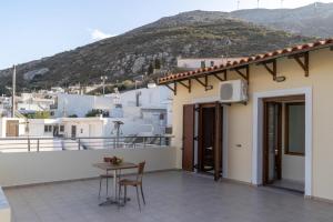 a balcony of a house with a table and chairs at House of Papadogiannis in Akoumia