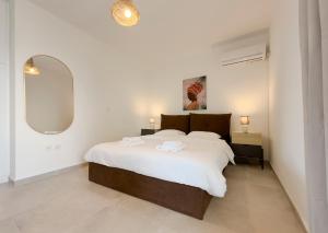 een slaapkamer met een groot bed en een spiegel bij Kanari Sea View 55sqm apt in Alimos in Athene