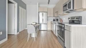 cocina con nevera de acero inoxidable y mesa en Landing Modern Apartment with Amazing Amenities (ID1241X658) en Tower Grove