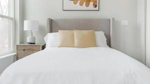 ein weißes Bett mit weißer Bettwäsche und Kissen im Schlafzimmer in der Unterkunft Landing Modern Apartment with Amazing Amenities (ID1241X658) in Tower Grove