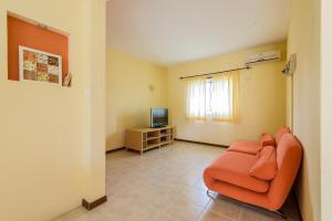 a living room with an orange couch and a television at Pereybere Beach Villas in Pereybere