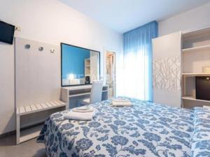 a bedroom with a blue and white bed and a tv at Hotel President in Cesenatico +18 photos