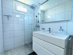 a white bathroom with a sink and a mirror at Appartement T4, climatisation, 50m de la plage in Cap d'Agde +32 photos