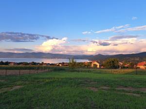 a field with a fence and a lake in the background at Od svitanja do sumraka in Golubac